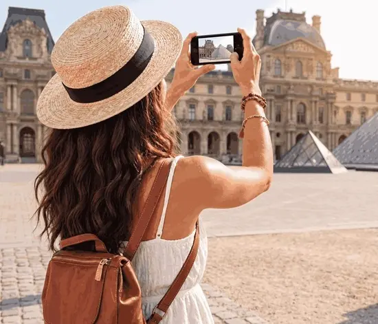 Turista fotografiando el Museo del Louvre en París